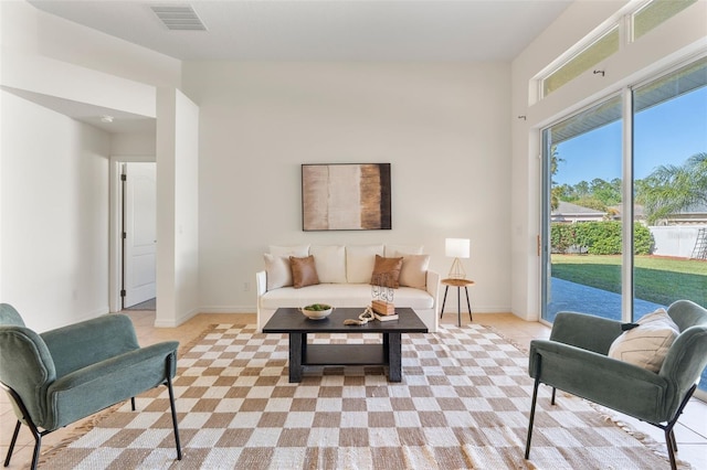 living area with baseboards and visible vents