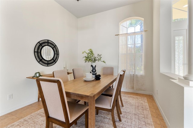 dining space with light tile patterned floors and baseboards