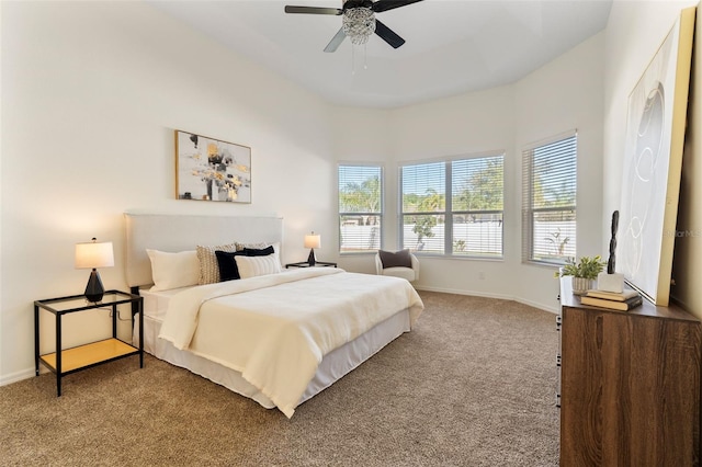 bedroom with a tray ceiling, baseboards, carpet floors, and ceiling fan