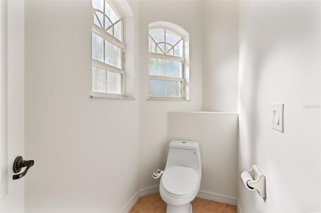 bathroom featuring tile patterned floors, toilet, and baseboards