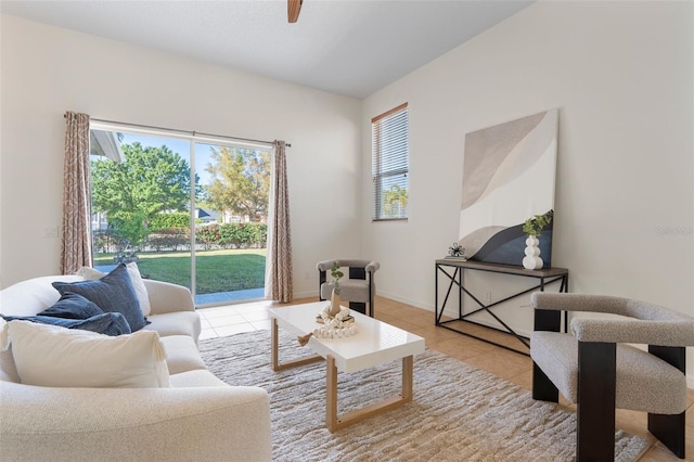 living room featuring tile patterned flooring, a ceiling fan, and baseboards