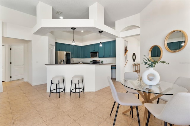 dining room featuring light tile patterned flooring, baseboards, visible vents, and a towering ceiling