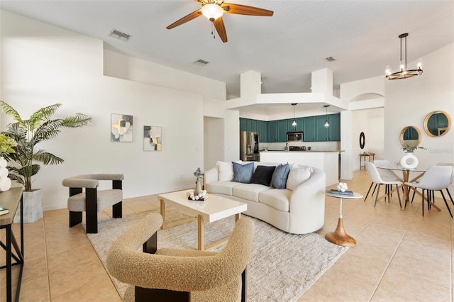 living area with light tile patterned floors, visible vents, and ceiling fan with notable chandelier