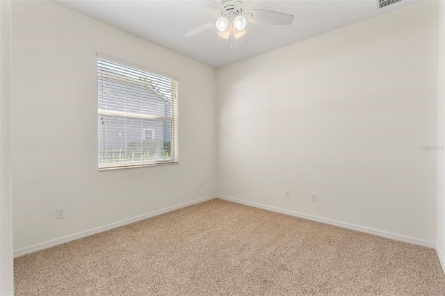 spare room featuring baseboards, light carpet, visible vents, and a ceiling fan