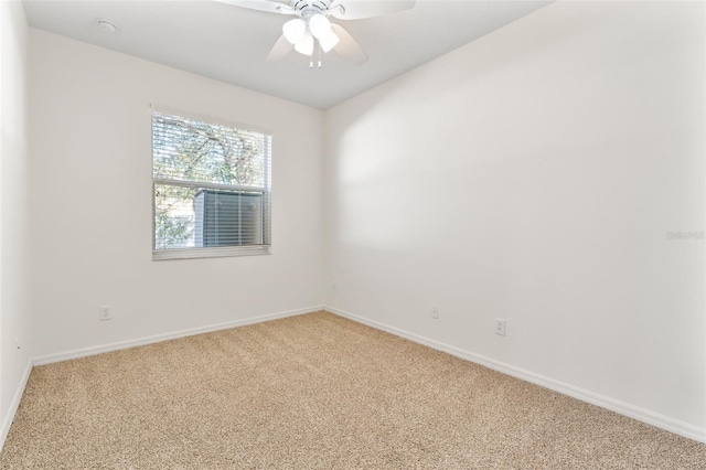 spare room featuring ceiling fan, baseboards, and light carpet