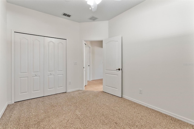 unfurnished bedroom featuring a closet, visible vents, light colored carpet, and baseboards