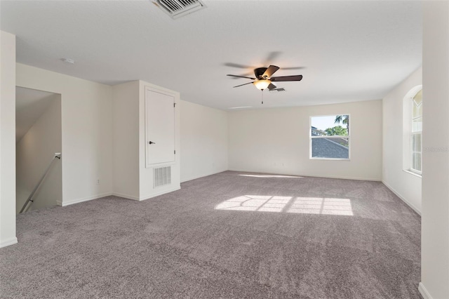 carpeted empty room with visible vents and ceiling fan