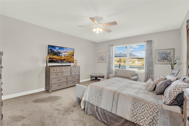 bedroom with ceiling fan, baseboards, and light carpet