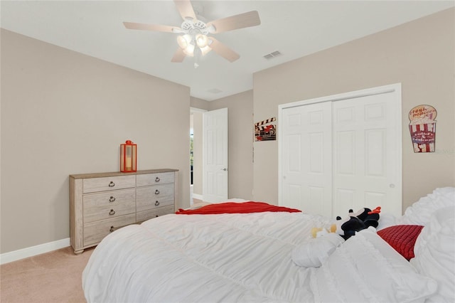 bedroom featuring visible vents, baseboards, light carpet, a closet, and a ceiling fan