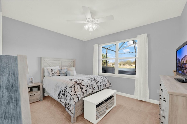 bedroom featuring baseboards, light colored carpet, and ceiling fan