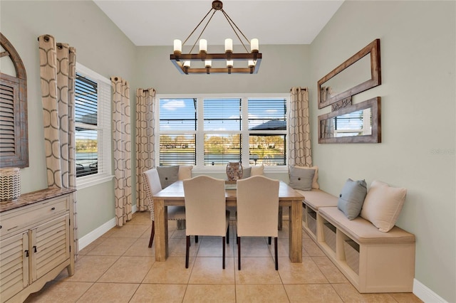 dining space featuring light tile patterned flooring, baseboards, and an inviting chandelier