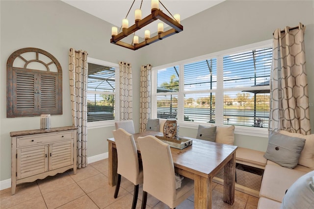 dining area featuring light tile patterned floors, baseboards, and a chandelier