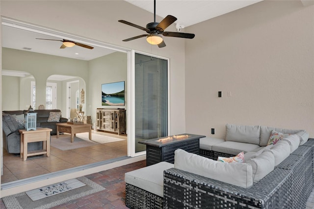 living room featuring arched walkways, visible vents, and brick floor