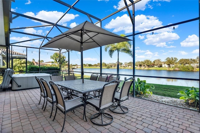 view of patio with a lanai and a water view