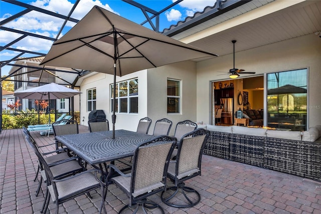 view of patio featuring glass enclosure, outdoor dining area, outdoor lounge area, and ceiling fan