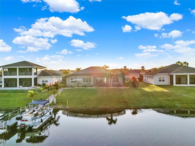 back of property with a water view and a lawn