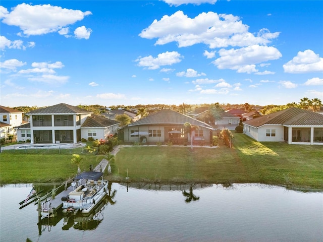 back of property featuring a yard, a water view, a residential view, and a sunroom