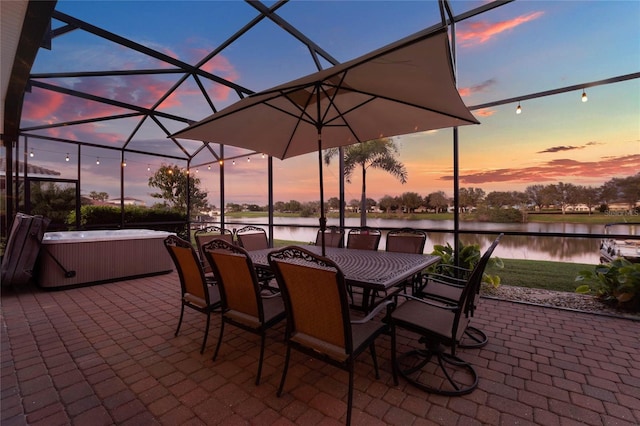 view of patio / terrace with outdoor dining area, a water view, a lanai, and a hot tub