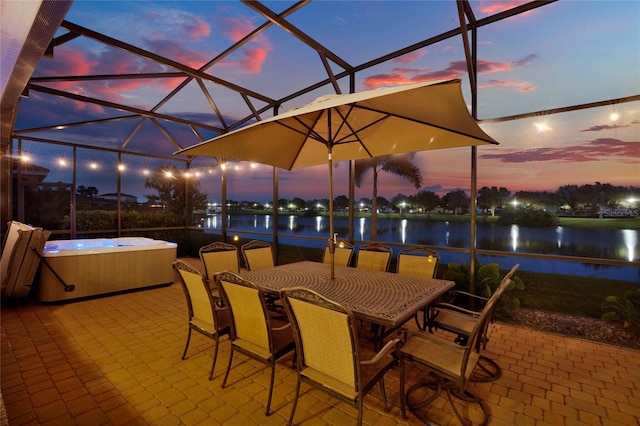 view of patio / terrace featuring outdoor dining area, a water view, a lanai, and a hot tub