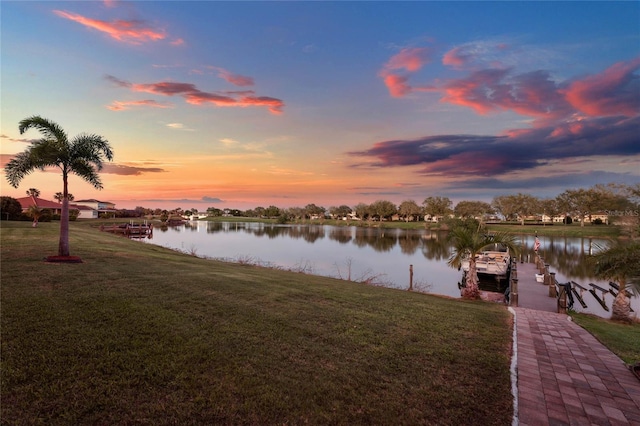 view of dock featuring a lawn and a water view