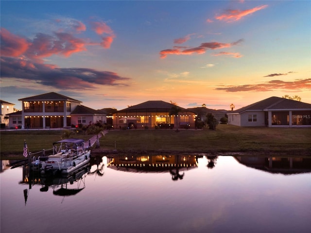 back of house at dusk with a gazebo and a water view