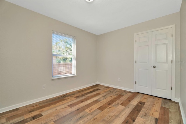 unfurnished bedroom featuring baseboards and light wood-style flooring