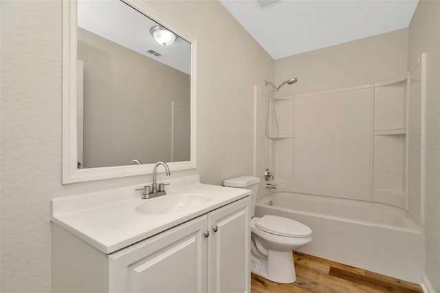 bathroom featuring vanity, wood finished floors, visible vents, bathing tub / shower combination, and toilet