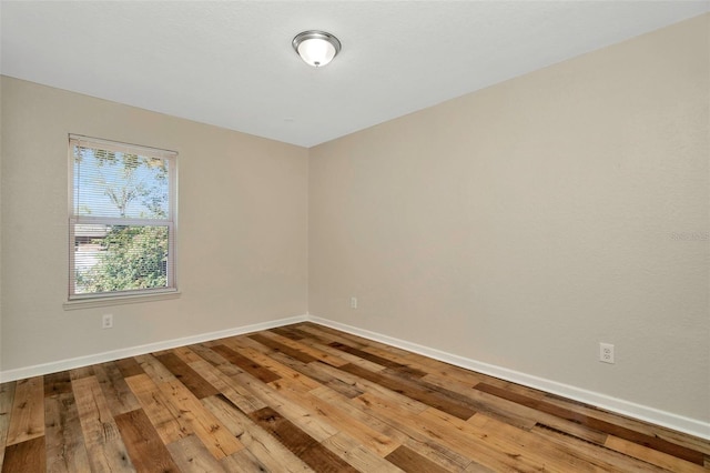 spare room featuring baseboards and wood-type flooring