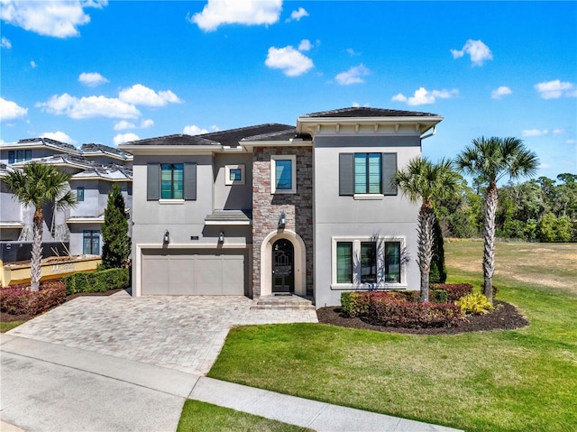 view of front of house featuring stucco siding, stone siding, a front lawn, and decorative driveway