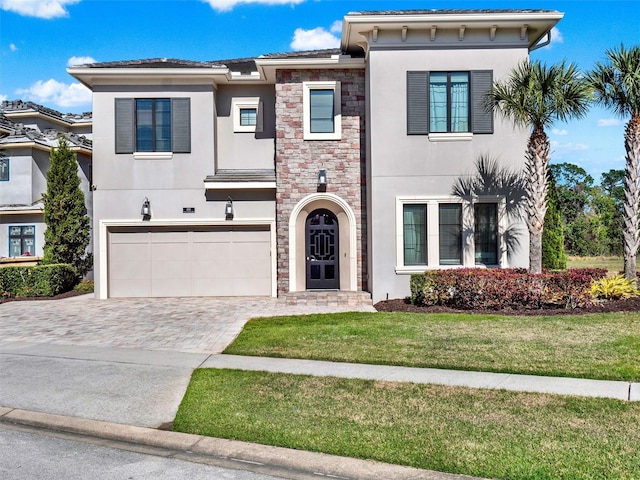 view of front of home with a front yard, stucco siding, decorative driveway, a garage, and stone siding