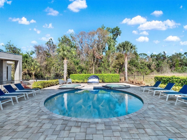 view of pool with a patio, a pool with connected hot tub, and fence