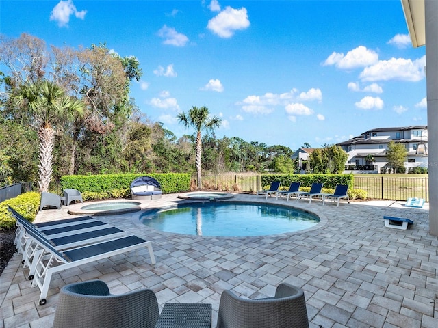 view of pool with an in ground hot tub, a fenced in pool, a patio area, and fence