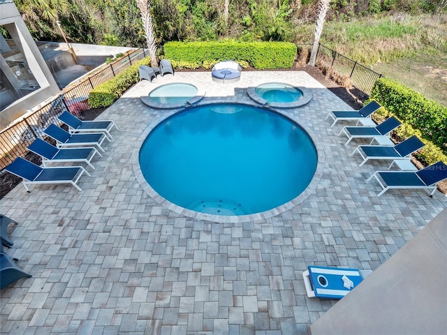 view of swimming pool featuring a fenced in pool, an in ground hot tub, fence private yard, and a patio