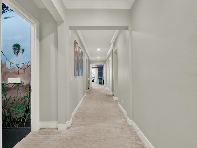 corridor featuring light carpet, recessed lighting, baseboards, and ornamental molding