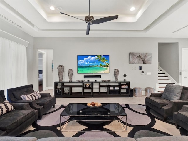 living area with stairway, recessed lighting, a raised ceiling, and a ceiling fan