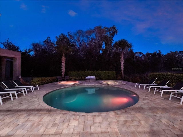 view of pool featuring an in ground hot tub, a patio area, and a fenced in pool