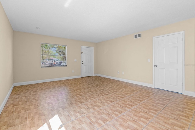 spare room featuring visible vents and baseboards