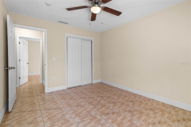 unfurnished bedroom with baseboards, visible vents, a closet, and a textured ceiling