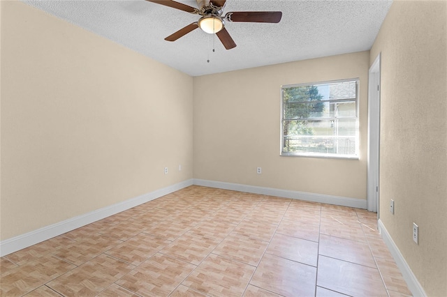 empty room with baseboards, a textured ceiling, light tile patterned flooring, and a ceiling fan