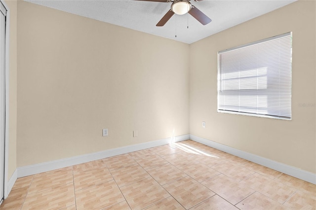 spare room featuring baseboards and ceiling fan