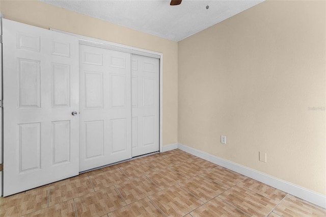 unfurnished bedroom with a closet, baseboards, and ceiling fan