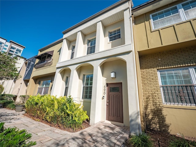 property entrance featuring brick siding and stucco siding