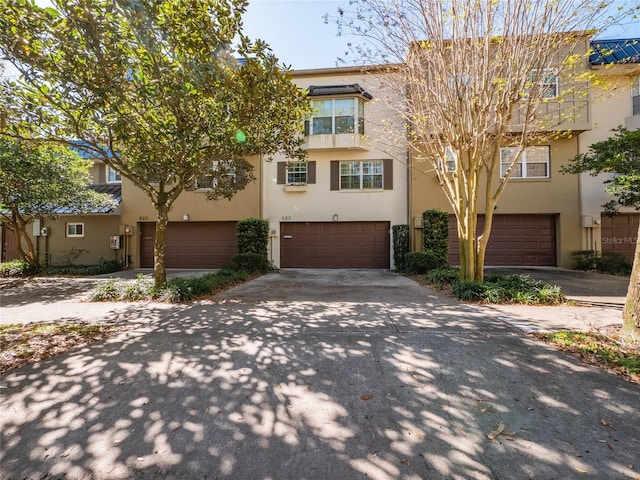 view of property featuring stucco siding, concrete driveway, and an attached garage