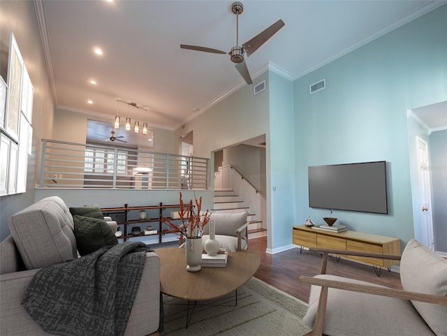 living room with ceiling fan, visible vents, wood finished floors, and crown molding