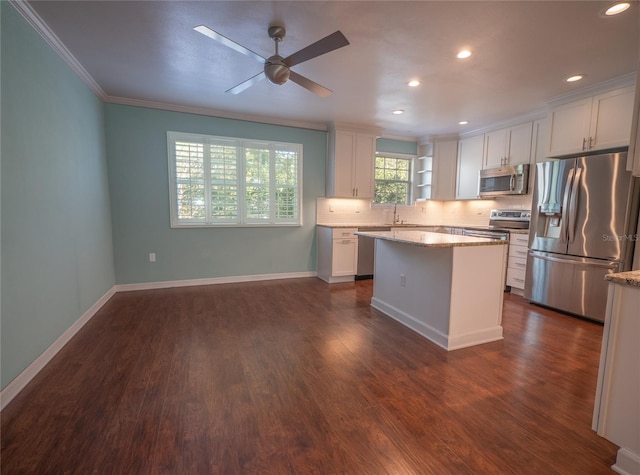 kitchen featuring stainless steel appliances, dark wood-type flooring, white cabinets, and crown molding