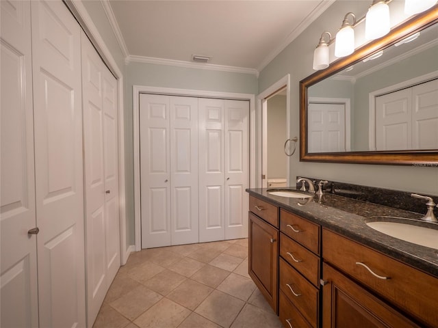 bathroom featuring ornamental molding, visible vents, a closet, and a sink