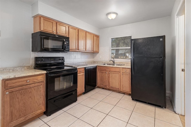 kitchen featuring a sink, black appliances, light tile patterned floors, and light countertops