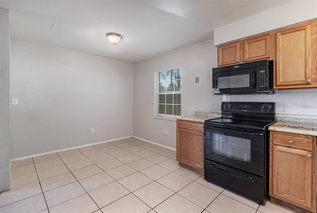 kitchen with brown cabinetry, baseboards, light tile patterned flooring, decorative backsplash, and black appliances