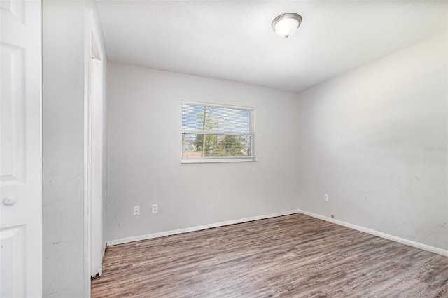 empty room featuring baseboards and wood finished floors