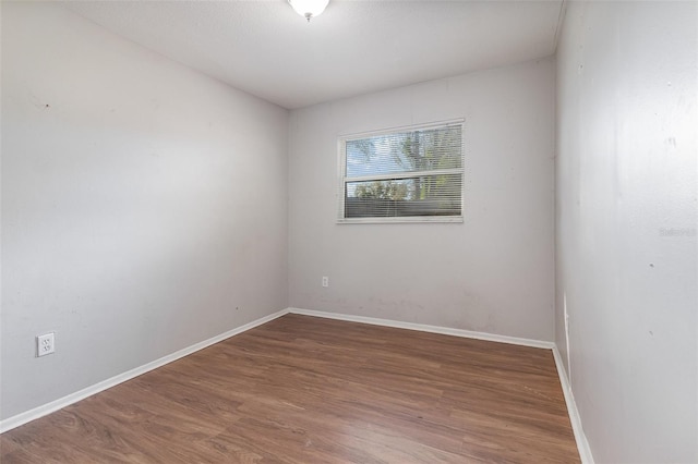 empty room with wood finished floors and baseboards